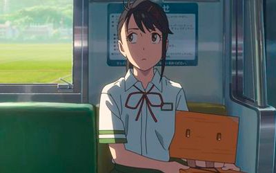 Suzume, con expresión decidida, viaja en el metro acompañada de Souta en su forma de silla, preparándose para una nueva aventura en la película Suzume.